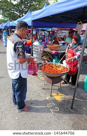 SHAH ALAM, MALAYSIA - JULY 11: A customer at a Ramadan food bazaar on July 11, 2013 in Shah Alam, Malaysia. The food bazaar is established for Muslim to break fast during the holy month of Ramadan.