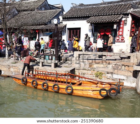 TONGLI, CHINA - JANUARY 2, 2015: A traditional wooden boat in the canal through the ancient town of Tongli, China. The town is placed under China National Key Cultural Relic Protection Unit.