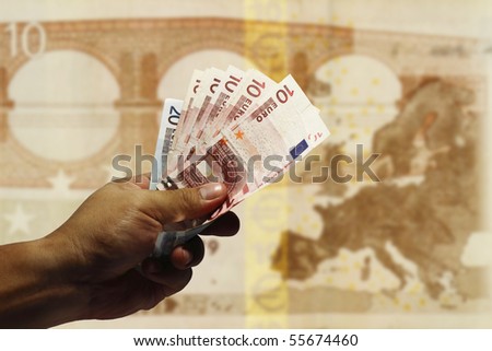 An image of a hand holding Euro currency with the continent of Europe as background.