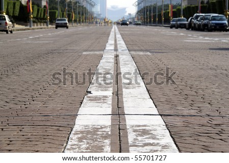 An image of a paved cobbled road along a main boulevard in a city.
