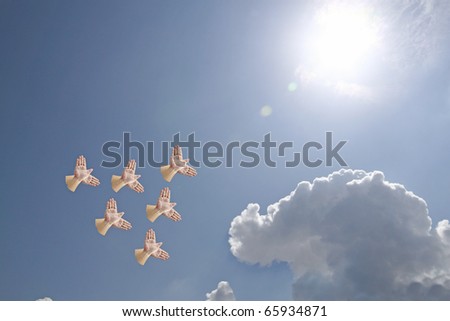 A flock of hand shadow puppet shaped like birds flying into the sun.