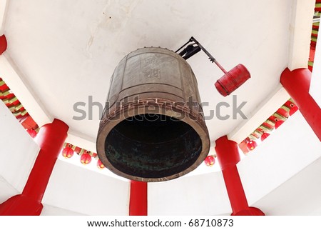 A vintage oriental bronze bell in a bell tower.
