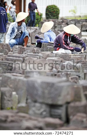 BOROBUDUR, INDONESIA - FEB 3: Workers sort out ancient stone masonry block on February 3, 2011 in Borobudur, Indonesia as the ongoing restoration effort of historical Borobudur temple