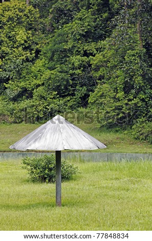 An exotic metal shelter at the fringe of a secondary forest in a green outdoor nature park.