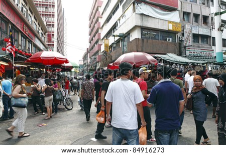 UALA LUMPUR, MALAYSIA - AUGUST 30: Shoppers in the crowded street bazaar on August 30, 2011 in Chinatown, Kuala Lumpur, Malaysia. The district is earmarked for demolition by 2012 for a new train line.