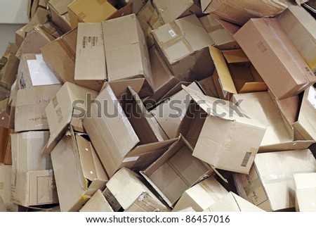 Discarded brown colored corrugated paper carton boxes piled up for recycle process.