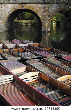 Vintage wooden boats moored on the bank of River Thames that run through the Oxford Botanic Garden, Oxford City, England.