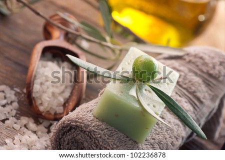 Natural spa setting with olive and olive oil products: bath salt, natural soap and olive oil.
