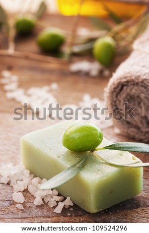 Natural spa setting with olive and olive oil products: bath salt, natural soap and olive oil.