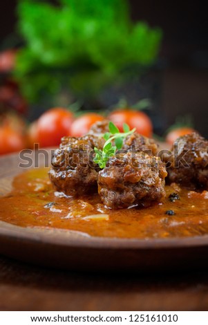 Italian cooking with beef meat balls with cherry tomatoes, tomato sauce and basil