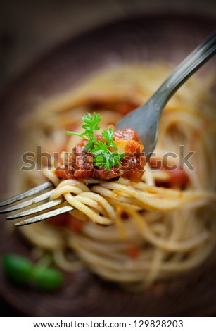 Italian food. Pasta spaghtti with tomato sauce, olives and garnish