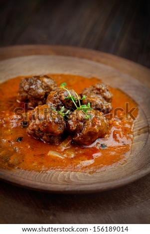 Italian cooking with beef meat balls with cherry tomatoes, tomato sauce and basil