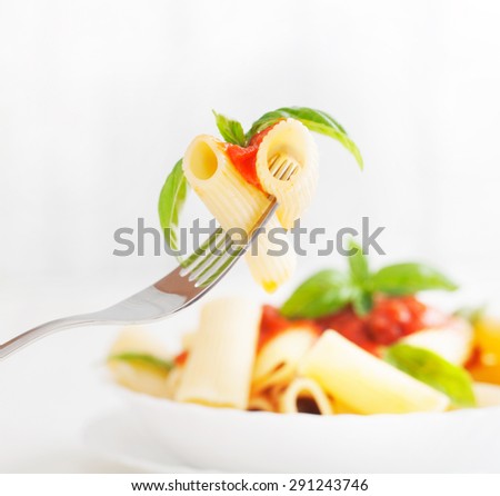 Pasta with Tomato Sauce and Basil on a Fork. Italian food. Mediterranean cuisine