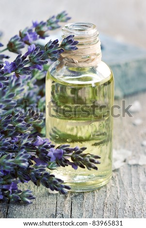Spa and wellness setting. Natural handmade lavender oil and soap with bath salt and fresh lavender on wooden background