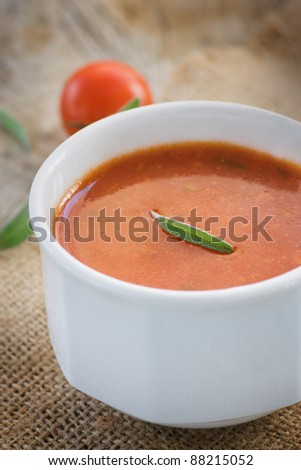 Fresh tomato soup with cherry tomatoes and fresh herbs and copyspace