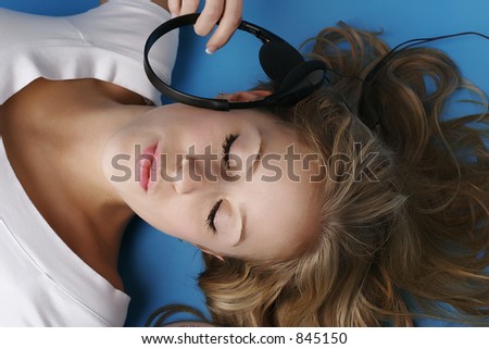 Female model on the ground with eyes closed and listening to music