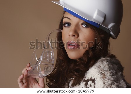 Female model wearing a white hard hat and holding safety glasses