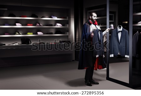 Dracula in a store trying on a suit on sale in the mirror