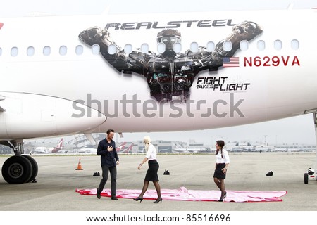 LOS ANGELES - SEPT 23:  Hugh Jackman with Virgin America flight attendants arrive as Virgin America unveils new DreamWorks 'Reel Steel' plane at LAX Airport on September 23, 2011 in Los Angeles, CA