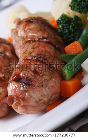 Grilled sausage with vegetables: green beans, and carrots on a plate closeup. macro. vertical