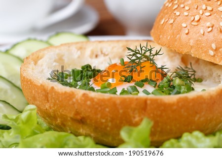 Sandwich with baked eggs with herbs and vegetables closeup on a white plate
