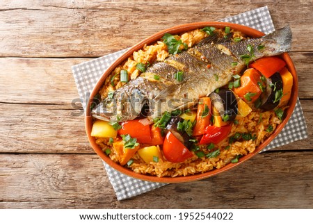 One-pot Thieboudienne Traditional West African Fish and Rice Dish with vegetables closeup in the dish on the table. horizontal top view from above