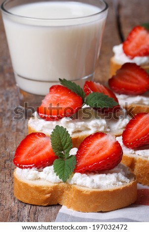 Breakfast of milk and sandwiches with strawberries and cheese on the table. closeup vertical