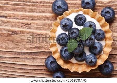 Tartlet with fresh blueberries on a wooden background horizontal view from above