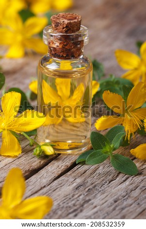 extract from the flowers of St. John\'s wort in a glass bottle macro vertical
