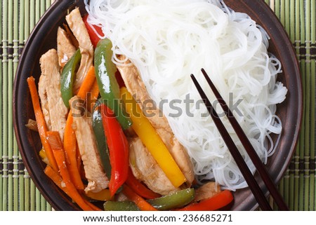 Chicken with vegetables and rice noodles close up. top view of a horizontal