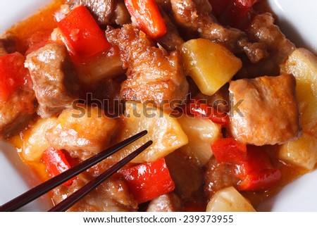 Pork meat with vegetables in sweet and sour sauce on a plate macro. horizontal view from above