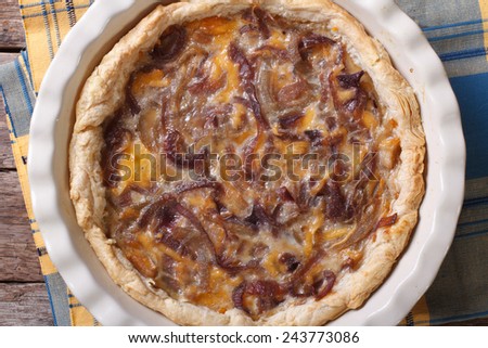 onion pie with cheese in baking dish on a table close-up. horizontal view from above
