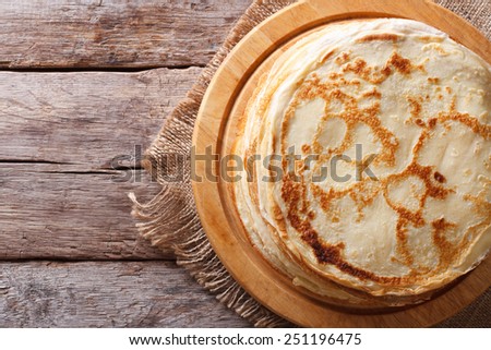 fried crepes on a chopping board on a table. horizontal view from above