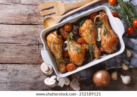Baked chicken legs with mushrooms and vegetables. horizontal view from above