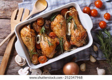 Baked chicken legs with vegetables close-up. horizontal view from above