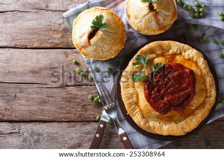 Australian meat pie on the table, a horizontal top view, rustic style