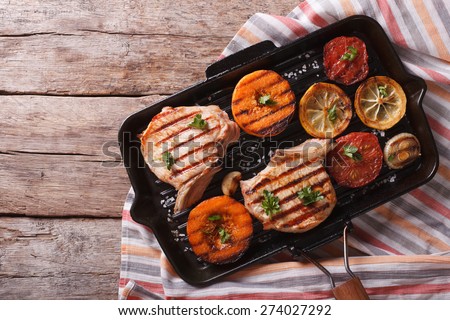 Grilled pork and pumpkin on a grill pan. horizontal view from above