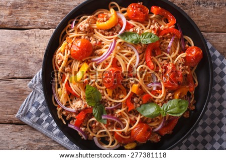 Spaghetti with minced meat and vegetables close-up. horizontal top view above, rustic style