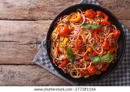 Spaghetti with minced meat and vegetables. horizontal top view, rustic style