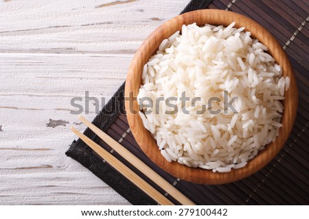 Japanese food: steamed rice in a wooden bowl and chopsticks. horizontal view from above
