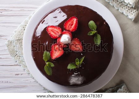 Fresh chocolate cake with strawberries on a table. Horizontal top view