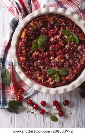 Clafoutis with cherry close-up in baking dish. vertical view from above, rustic