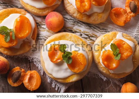 Apricot cakes with cream and mint close-up on the table. horizontal view from above