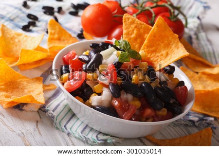 Mexican Food: salsa with black beans in a bowl and corn chips nachos closeup. horizontal