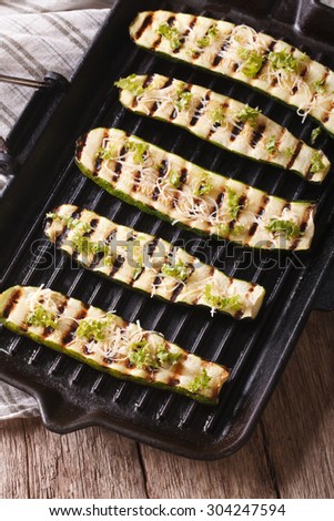 grilled zucchini with cheese on a grill pan close-up. vertical