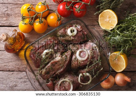 Marinated meat with onions and herbs in a bowl close up. horizontal view from above