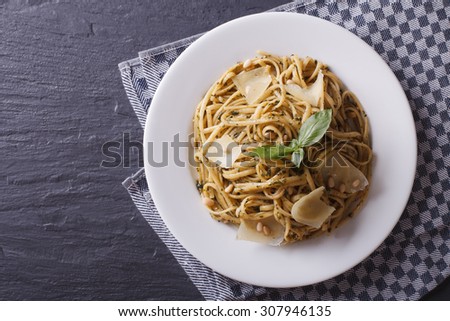 pasta with pesto, pine nuts and parmesan cheese on a plate. horizontal view from above