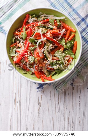 vegetable salad with sprouts, peppers and sesame seeds in a bowl. Vertical top view