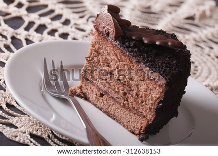 A slice of chocolate truffle cake on a plate on a table close-up. horizontal