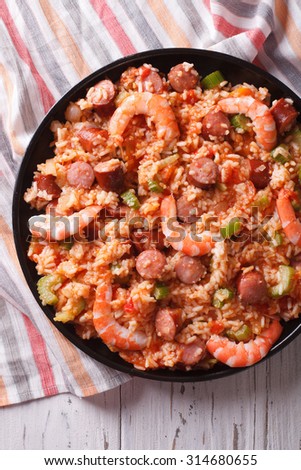 Delicious Creole jambalaya with shrimp and sausage close-up on a plate. vertical top view